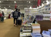 Pistas. Jóvenes en maletas llevan libros comprados en feria de El Cairo.