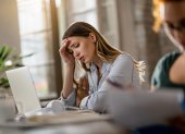 Young displeased businesswoman having a headache while working in the office.