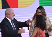 El presidente de Brasil, Luiz Inácio Lula da Silva, junto a su esposa, Janja da Silva, saluda a la ex beneficiaria de Bolsa Familia, Isamara Mendes da Silva, durante el nuevo lanzamiento de ese programa brasileño de combate el hambre, hoy, en el Palacio del Planalto en Brasilia (Brasil). Lula da Silva relanzó este jueves un programa de subsidios que en sus primeros dos mandatos (2003-2010) redujo las tasas de pobreza y que ahora pretende rescatar del hambre a unas 33 millones de personas. El nuevo Bolsa Familia estará dotado con unos 175.000 millones de reales (33.650 millones de dólares), cifra equivalente a cerca del 1,5 % del Producto Interno Bruto (PIB), y se calcula que atenderá a unas 60 millones de personas (poco más del 30 % de la población). EFE/ Andre Borges