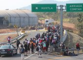 Migrantes caminan en caravana en una carretera de México.