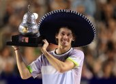 El tenista australiano Alex De Minaur, celebra con el trofeo de campeón al derrotar al estadounidense Tommy Paul.