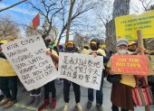 Decenas de vendedores ambulantes, de diversos grupos étnicos, sostienen carteles en varios idiomas con sus demandas durante una protesta relizada hoy frente a la Alcaldía de Nueva York.