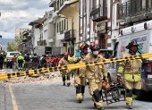 Miembros de los bomberos ayudan con los daños ocasionados por el sismo de magnitud 6,5 en la escala abierta de Richter hoy, en la ciudad de Cuenca (Ecuador).