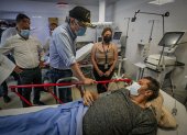 Fotografía cedida por Presidencia que muestra al presidente de Ecuador, Guillermo Lasso (c), mientras visita a los heridos por el terremoto hoy, en el Hospital del Seguro Social en la ciudad de Machala (Ecuador).