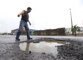 Reclamos. Un ciudadano se queja por los enormes baches que se observan en Mucho Lote 2, en Guayaquil. Los peatones también quieren demandar por los perjuicios provocados.