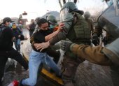 Fotografía de archivo, tomada en septiembre de 2020, en la que se registró a un grupo de carabineros chilenos al forcejear con una manifestante, en Santiago de Chile.