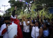Un sacerdote bendice a los feligreses durante la celebración del Domingo de Ramos.