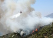 Equipos aéreos tratando de apagar el incendio declarado en un monte en el centro de Seul.