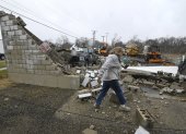Una mujer pasa frente a un negocio destruido tras un tornado en Belvidere, Illinois, EE.UU.