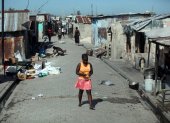 Imagen de archivo de una mujer camina por una calle en el barrio Cité Soleil de Puerto Príncipe (Haití).