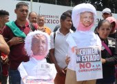 Migrantes protestan hoy frente a la estación migratoria Siglo XXI en la ciudad de Tapachula, estado de Chiapas (México). Migrantes quemaron este viernes dos piñatas con la imagen del presidente mexicano, Andrés Manuel López Obrador, y el director del Instituto Nacional de Migración (INM), Francisco Garduño, para denunciar los abusos y la muerte de los 40 migrantes que fallecieron en un incendio en Ciudad Juárez.