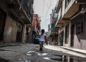 Hecho. Una niña  atraviesa la calle de una de las villas en la Ciudad de Buenos Aires.