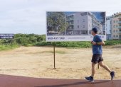 Un hombre pasa frente a una publicidad de venta de obra nueva en Maó, Menorca, este lunes.