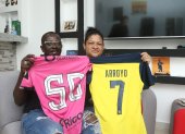 Silvia Alvarado y Grober Arroyo sostienen con orgullo las camisetas de su hijo Kenny Arroyo.