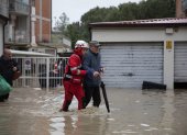 Un miembro de la Cruz Roja Italiana ayuda a las personas a salir de sus apartamentos tras la crecida del río Savio, en Cesena, Italia, el 16 de mayo de 2023.