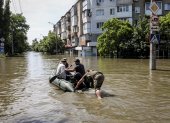 Personas se mueven en un bote inflable por las calles de la inundada ciudad de Jerson, este miércoles 7 de junio.