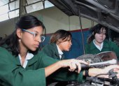 Alejandra Andrade, Mercedes Perea y Antonella Sánchez revisan el motor de un carro como parte de su aprendizaje en la especialización Electromecánica.