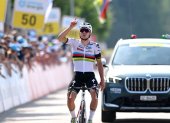 Evenepoel llegando a la meta mientras apuntaba al cielo en honor al ciclista fallecido.