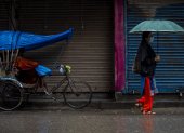 una mujer caminando bajo la lluvia en Kathmandu (Nepal).