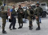 Oficiales de las fuerzas de seguridad israelíes hacen guardia junto al cuerpo de un presunto atacante en la escena de un tiroteo en el asentamiento de Eli, entre Nablus y Ramallah, en Cisjordania, el 20 de junio de 2023