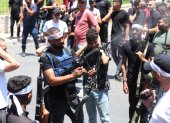 Un militante palestino dispara al aire mientras asistía al funeral de los dos hombres muertos durante una redada israelí en la ciudad de Nablus.