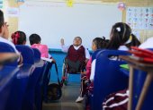 Dedicación. Sobre su silla de ruedas, la maestra Clara Celi imparte enseñanza a los estudiantes de la escuela fiscal Benjamín Rosales.