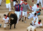 Un mozo es arrollado por uno de los toros de la ganadería de Fuente Ymbro en su entrada a la plaza de toros de Pamplona, el lunes 10 de julio.