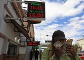 Divisa.- Una mujer muestra los dólares frente a la casa de cambios.