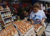 Mercado. Delia Córdova, cliente, selecciona los huevos para comprar.
