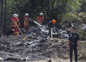 Oficiales del Depmento de Bomberos y Rescate de Malasia inspeccionan la escena del accidente de una avioneta en Elmina, estado de Selangor, Malasia. EFE/EPA/FAZRY ISMAILarta