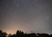 Fotografía de larga exposición durante la lluvia de estrellas de las Perseidas sobre la localidad cántabra de Comillas.