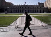 Un hombre camina usando mascarilla frente al Palacio de la Moneda, en Santiago.