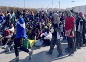 Un grupo de migrantes espera en la isla de Lampedusa mientras las autoridades italianas se preparan para trasladar a las personas tras los recién llegados, Italia, 13 de septiembre de 2023