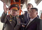 , Kim Jong-un (d), y al ministro de Defensa ruso, Serguéi Shoigú (i), inspeccionando aviones militares rusos en el aeródromo de Knevichi, cerca de Vladivostok