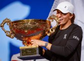 Beijing (China), 08/10/2023.- Iga Swiatek of Poland bites her trophy after winning the Women"s Singles Final match against Liudmila Samsonova of Russia (not pictured) at the China Open tennis tournament in Beijing, China, 08 October 2023. (Tenis, Polonia, Rusia) EFE/EPA/MARK R. CRISTINO