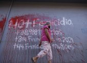 una mujer al caminar frente a un aviso pintado en una pared en contra del femicidio en Honduras, en una calle de Tegucigalpa.