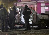 Fotografía de archivo fechada el 31 de agosto de 2023 que muestra a un grupo de policías junto a los restos de un carro bomba que explotó en los exteriores del edificio del Servicio Nacional de Atención Integral a Personas Privadas de Libertad (SNAI), en Quito (Ecuador).