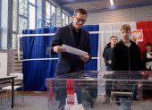 El primer Ministro polaco, Mateusz Morawiecki (c), deposita su voto en Varsovia