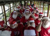 Hombres disfrazados de Papá Noel abordan el turístico "tranvía de Santa Tereza", en Río de Janeiro (Brasil)