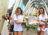Mimi Barona, hermana de Israel, y la esposa del surfista llevan la ofrenda que se depositó en el mar.