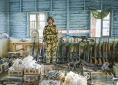 Un soldado de la milicia Fuerza para la Defensa del Pueblo Chin posa con un arsenal.