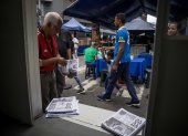 Caracas.  Un hombre toma un periódico del camión de información.