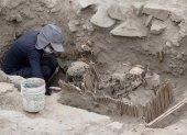 Aarqueólogos mientras trabajan con momias halladas en una pirámide prehispánica, en Lima (Perú).