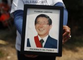 Fotografía de archivo en la que se registró a un seguidor del expresidente peruano Alberto Fujimori al sostener en sus manos una foto del exmandatario, en Lima (Perú).