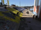 Activistas pintan un mural para denunciar la violencia de género y el maltrato a los migrantes, junto al río Bravo en Ciudad Juárez, estado de Chihuahua (México).