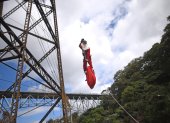 Héctor Chacón, mayor de los Bomberos Municipales, desciende hoy del puente ferroviario Las Vacas durante el acto de entrega de regalos a niñas y niños de escasos recursos del asentamiento Jesús de la Esperanza, en Ciudad de Guatemala (Guatemala).