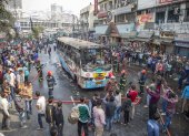 Una gran cantidad de personas rodean el autobús que se incendió ayer en la ciudad de Dacca, este 19 de diciembre de 2023.