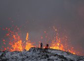 Un equipo de científicos trabaja, en la cresta de una fisura volcánica mientras sale lava durante una erupción volcánica, cerca de la ciudad de Grindavik, en la península de Reykjanes (Islandia).