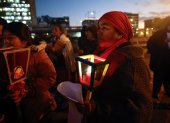 Un grupo de mujeres indígenas acompaña con velas una posada navideña contra la corrupción para exigir el "respeto a la democracia".