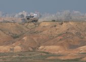 Un vehículo blindado del ejército israelí patrulla una zona con vistas al barrio de Shujaiya en la Franja de Gaza, cerca de la frontera entre Israel y Gaza en el sur de Israel, el 30 de diciembre de 2023.